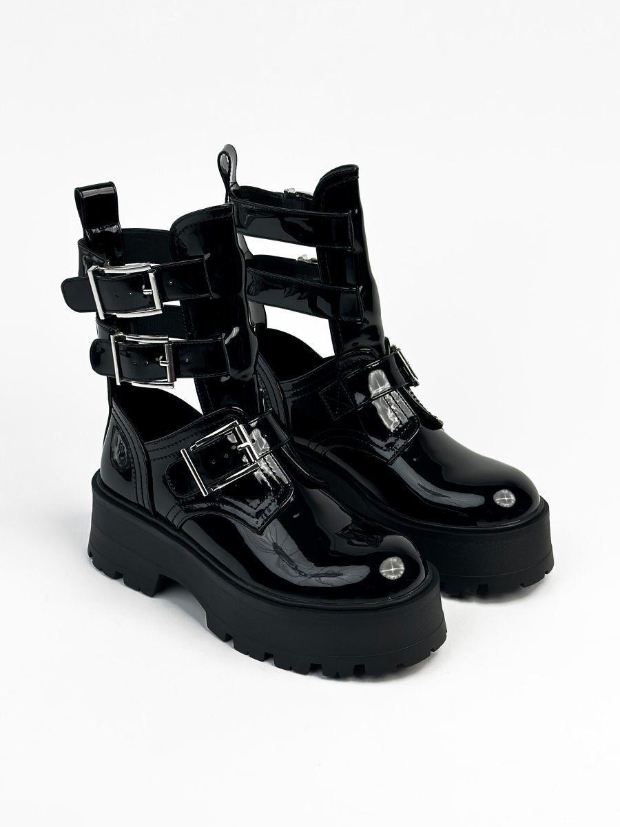 أحذية جلدية سوداء لامعة ذات نعل سميك وأحزمة