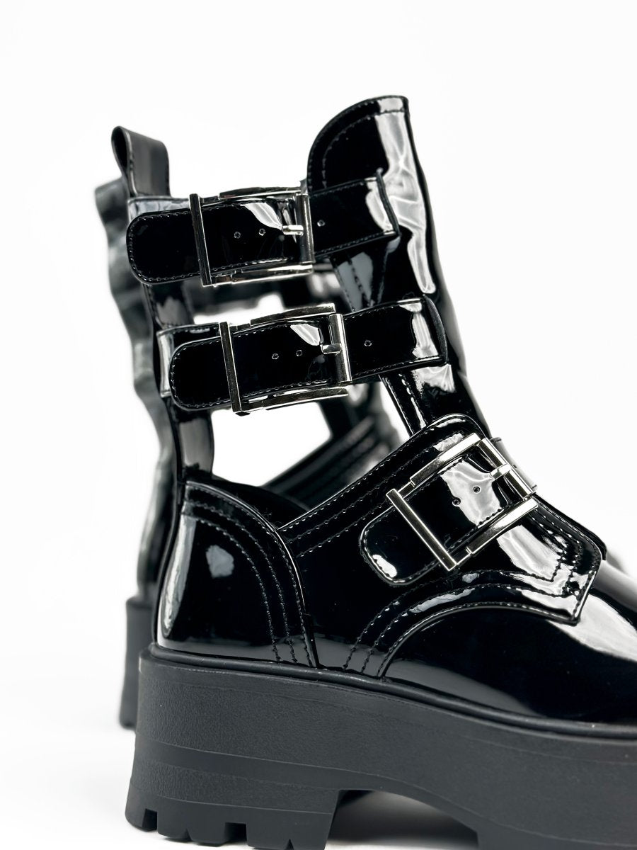 أحذية جلدية سوداء لامعة ذات نعل سميك وأحزمة