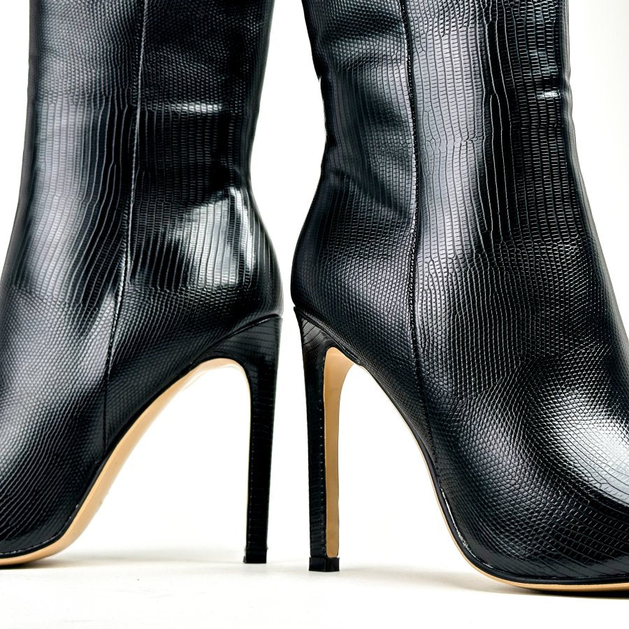 حذاء أسود من الجلد يصل إلى منتصف الساق